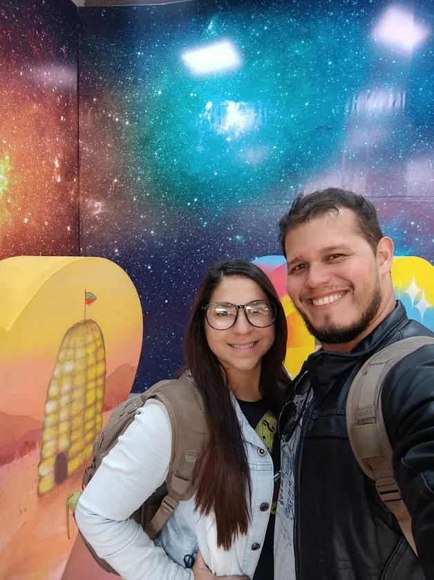 desarrolladora con lentes y desarrollador con bolsos y fondo de colores